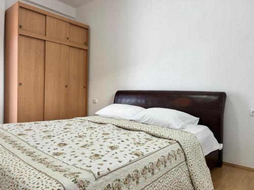 sypialnia z łóżkiem i drewnianą szafką w obiekcie Apartmani Andric w mieście Trebinje