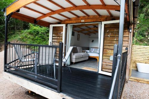 a porch of a tiny house with a pergola at Wildwood Quarry Retreat in Mold