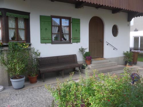 a house with green shutters and a bench in front at Haus Mayer in Weilheim in Oberbayern