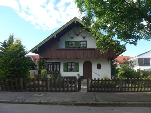 una pequeña casa blanca con techo marrón en Haus Mayer en Weilheim in Oberbayern