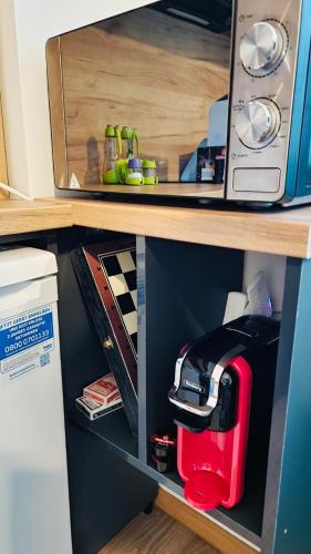 a red toaster sitting inside of a microwave at STELIA view apartment in Panayia