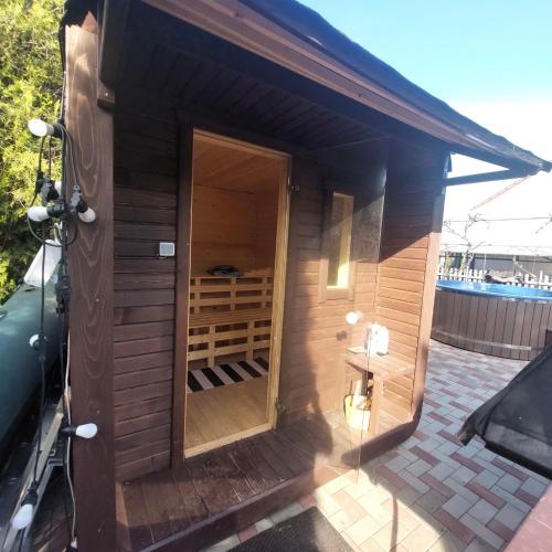 a small wooden building with a door in the middle at La Florina in Şuncuiuş