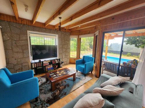 a living room with a blue couch and a tv at Casa Algarrobo antiguo in Algarrobo