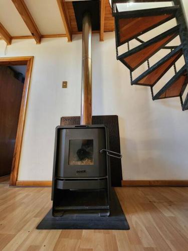 a wood stove in a room with a staircase at Casa Algarrobo antiguo in Algarrobo