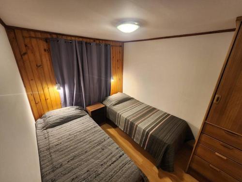 a small bedroom with two beds and a window at Casa Algarrobo antiguo in Algarrobo
