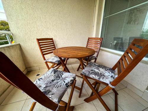 a table and chairs on a porch with a window at Sunshine Romance Apartment in Kranevo