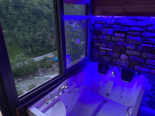 baño con 2 lavabos y 2 ventanas con luces azules en Sisorti süit bungalov en Rize