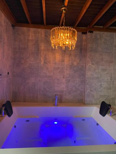 a bath tub in a bathroom with a chandelier at Magicgarden in Bello
