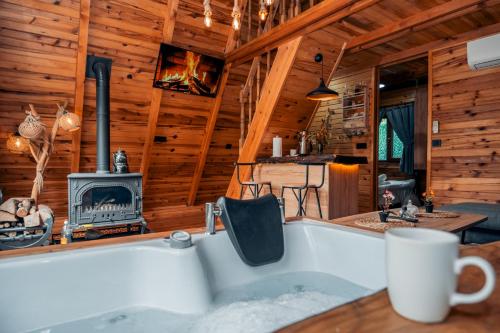 a bath tub in a log cabin with a fireplace at Bi Başka Bungalov in Ardeşen