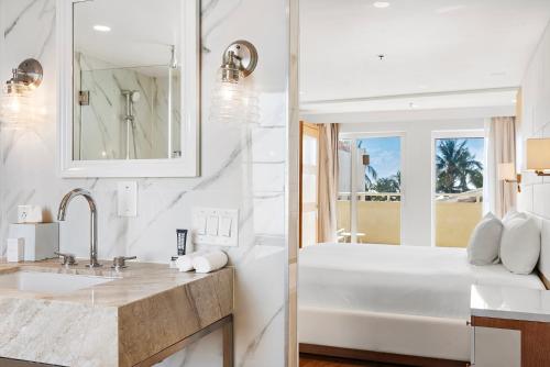 een witte badkamer met een bad en een wastafel bij Hotel Ocean in Miami Beach