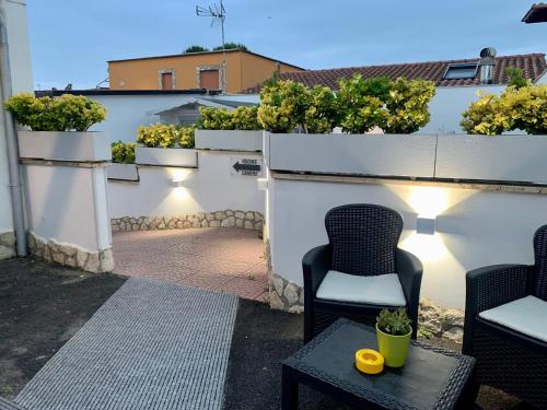 a patio with chairs and plants on a white wall at Airport Hotel in Fiumicino