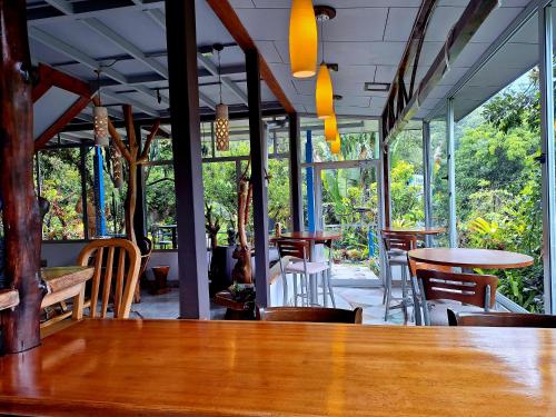 Rivas的住宿－Talamanca Nature Reserve，餐厅设有桌椅和窗户。