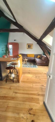a living room with a couch and a desk in a room at Les studios du 4 Canal - 2 grands studios indépendants proche du Loing et du centre historique de Nemours in Saint-Pierre-lès-Nemours
