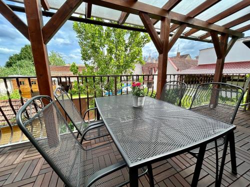 a patio table and chairs on a deck with a pergola at Apartmány Strážnice in Strážnice