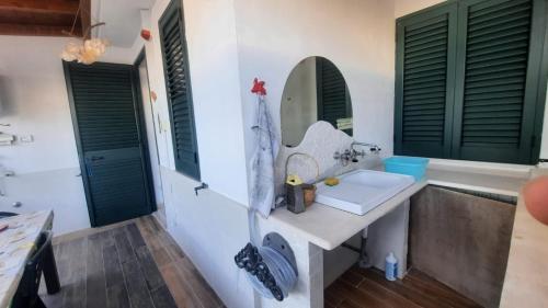 un baño con lavabo y espejo en LaCasaDeiGechiOtranto, en Casamassella