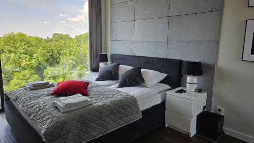 a bedroom with a bed with a large window at YOUR Apartment Unia Art Residence in Lublin