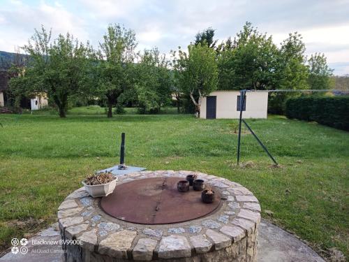 a fire pit in the middle of a yard at La Clematite d'Olt in Saint-Côme-dʼOlt