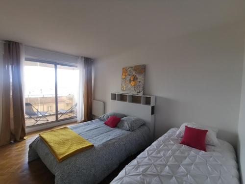 - une chambre avec 2 lits et une grande fenêtre dans l'établissement Toulouse Saint Georges SG3, T3, 2ch terrasse Pk, à Toulouse