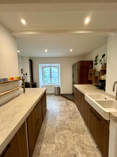 une grande cuisine avec des placards en bois et un évier dans l'établissement Mas Chantequinson, à Les Assions