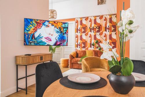 d'un salon avec une table et une peinture murale. dans l'établissement MM Suites Loft Cathédrale, à Reims