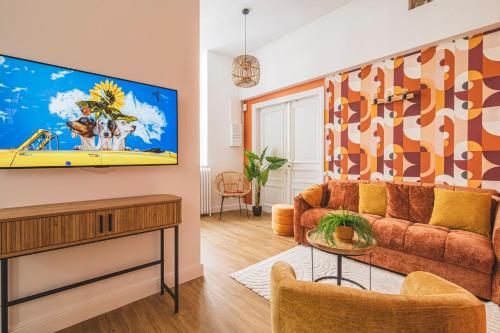 un salon avec un canapé et une télévision à écran plat dans l'établissement MM Suites Loft Cathédrale, à Reims