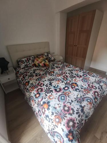 a bed with a floral comforter in a bedroom at PIso recién reformado y espacioso in Haro