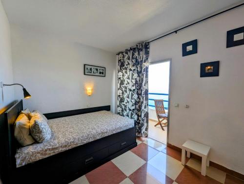 a bedroom with a bed and a view of the ocean at Studio Playa Paraiso Tenerife - ocean view and internet wifi optical fiber - for rent in Playa Paraiso
