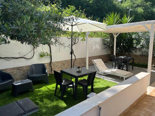 un patio con mesa, sillas y sombrilla en B&B Giordano, en Porto SantʼElpidio