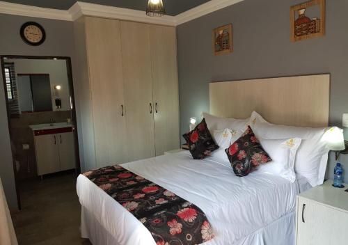 a bedroom with a large white bed with pillows at Rekky Signature Guesthouse in Johannesburg