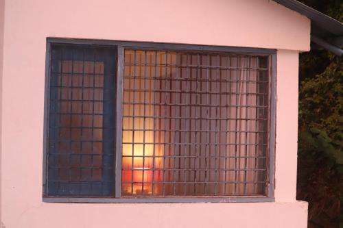 a window of a building with a sunset in it at Maayaa Ridge House in Kanatal