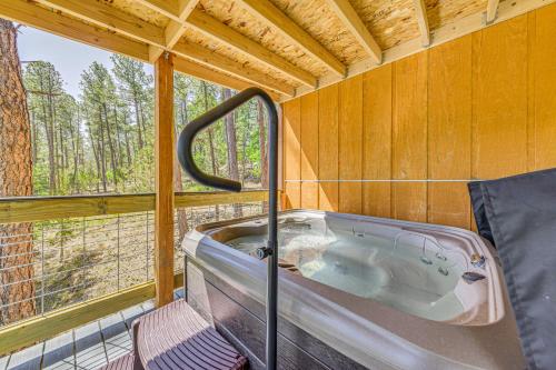 a bath tub in a room with a window at Ruidoso Cabin Rental with Hot Tub Near Midtown! in Ruidoso