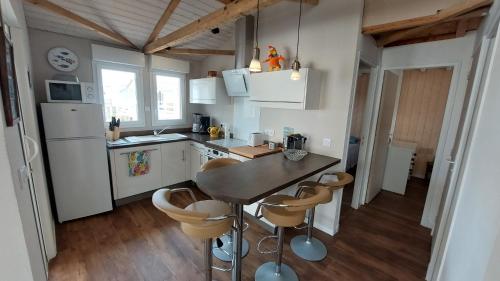 une cuisine avec une table et quelques chaises dans l'établissement CHALET proche MER, à Gruissan