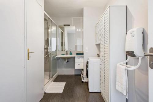 ein weißes Badezimmer mit Waschbecken und Spiegel in der Unterkunft La Goélette Malo-les-Bains in Dunkerque