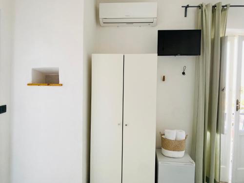 a bathroom with a white refrigerator and a toilet at Black Market Hotel in Ischia