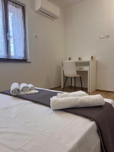 アルゲーロにあるRita's House Algheroのタオルが敷かれたベッドのある寝室