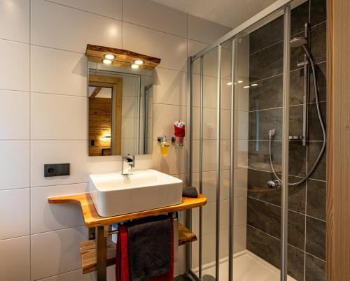 a bathroom with a sink and a shower at Gasthaus Traube in Bichlbach