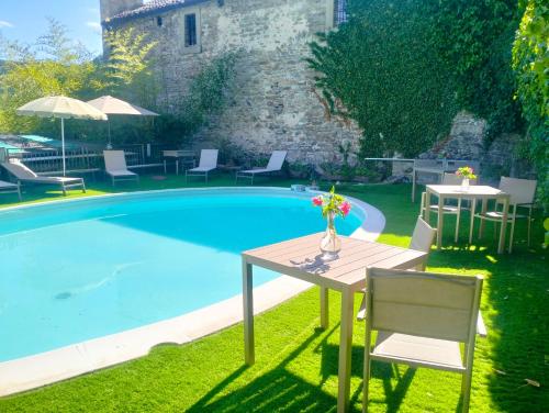 a table and chairs next to a swimming pool at Locanda Senio in Palazzuolo sul Senio