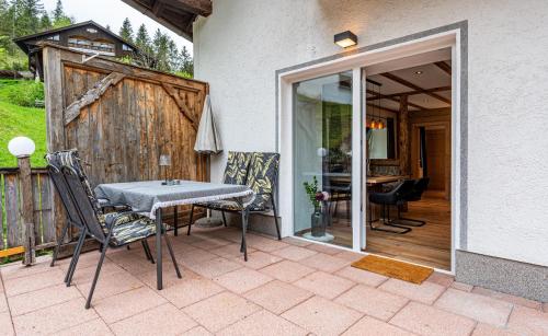 a patio with a table and chairs and a sliding glass door at Gasthaus Traube in Bichlbach