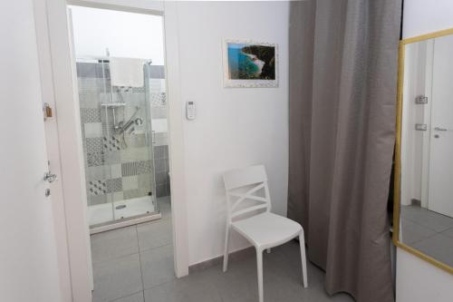 a white chair in a bathroom with a shower at Residenza Luce Sul Mare in Tropea