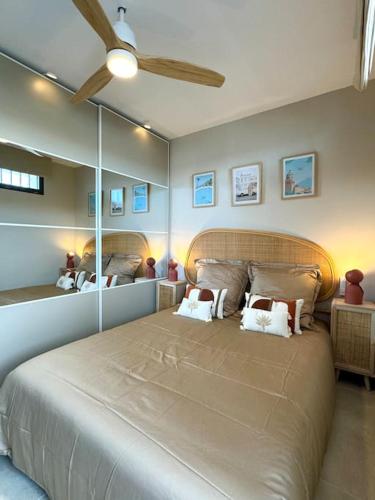 - une chambre avec un grand lit et des miroirs au mur dans l'établissement Vistalmar La-Grande-Motte, à La Grande Motte