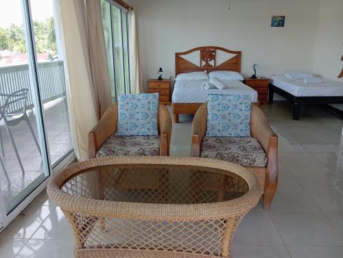 Pokój z 2 krzesłami i łóżkiem oraz balkonem w obiekcie Los Balcones Over The Sea w mieście Carenero
