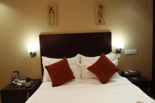 a bedroom with a large white bed with red pillows at Rekky Signature Guesthouse in Johannesburg