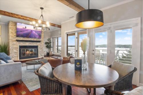 a living room with a table and chairs and a fireplace at Emerald Bay Unit 1B in Lake Ozark