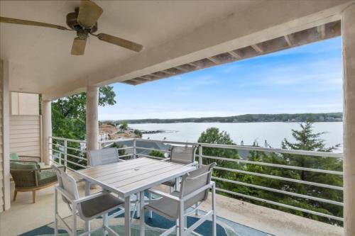 a porch with a table and chairs and a view of the water at Emerald Bay Unit 1B in Lake Ozark