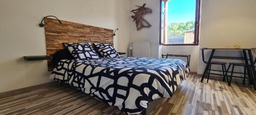 una camera da letto con un letto con un piumone bianco e nero di Gîte climatisé "Baugallo Acampadis" a Saint-Montan