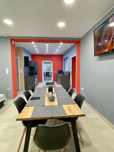 a dining room with a long table and chairs at K71 Guest House in Fertőd