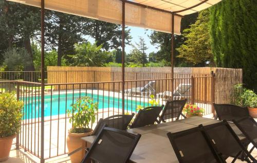 un patio avec une table et des chaises et une piscine dans l'établissement Provence Mas de caractère à MONTEUX entre AVIGNON LUBERON Mt VENTOUX, à Monteux