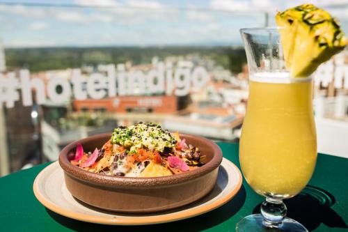 a bowl of food next to a glass of orange juice at Hotel Indigo Madrid - Gran Vía by IHG in Madrid