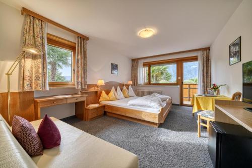 a hotel room with a bed and a table at Hotel Bellevue in Tirolo