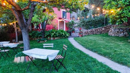 uma mesa e cadeiras num quintal com uma parede de pedra em Tana Libera Tutti 1 Nature, Yourself, Love em Viggianello